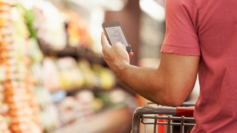 man looking at grocery list on phone